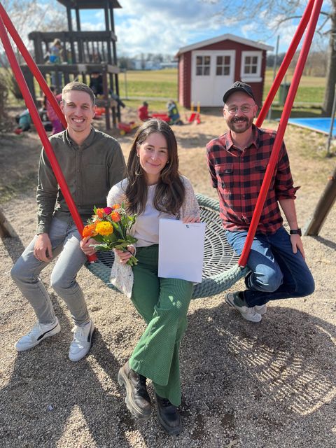 Mit einem bunten Frühlingsstrauß begrüßt Abteilungsleiter Rouven Rudisile (links) Frau Yildiz in der Gemeinde. Philipp Wöhr, Leiter der Kita Abenteuerland rechts im Bild. 