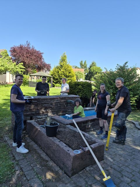 Jürgen Treiber, 1. Vorstand des Obst- und Gartenbauvereins, (rechts) koordinierte die Arbeiten am Brunnen und Bürgermeister Helge Viehweg (links) fand Gefallen am handwerklichen Arbeiten.