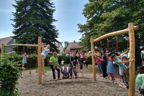 Gemeinsam mit den Kindern begutachten Barbara Drollinger (Abteilung Bildung, Familie und Kultur), Kerstin Föll (Leiterin der Kita Kunterbunt) und Saskia Toth (Stellvertretende Leitung) das neue Spielgerät (von links). 