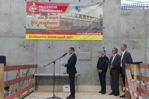 Bürgermeister Helge Viehweg (links) vor dem Grundstein, der eine Zeitkapsel für die Nachwelt abdeckt. Foto: Gemeinde