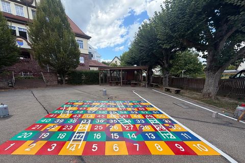Auf den Schulhof wurde unter anderem ein lebensgroßes Leiterspiel gemalt.