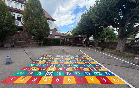 Auf den Schulhof wurde unter anderem ein lebensgroßes Leiterspiel gemalt.