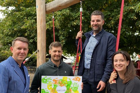 Einrichtungsleiterin Kerstin Föll überreicht Benjamin Stieler (zweiter von links) ein "Dankeschön" der Kita Kinder. Bürgermeister Helge Viehweg (links) und Fachbereichsleiter Benedikt Lorsch freuen sich über den Einsatz von Stieler.